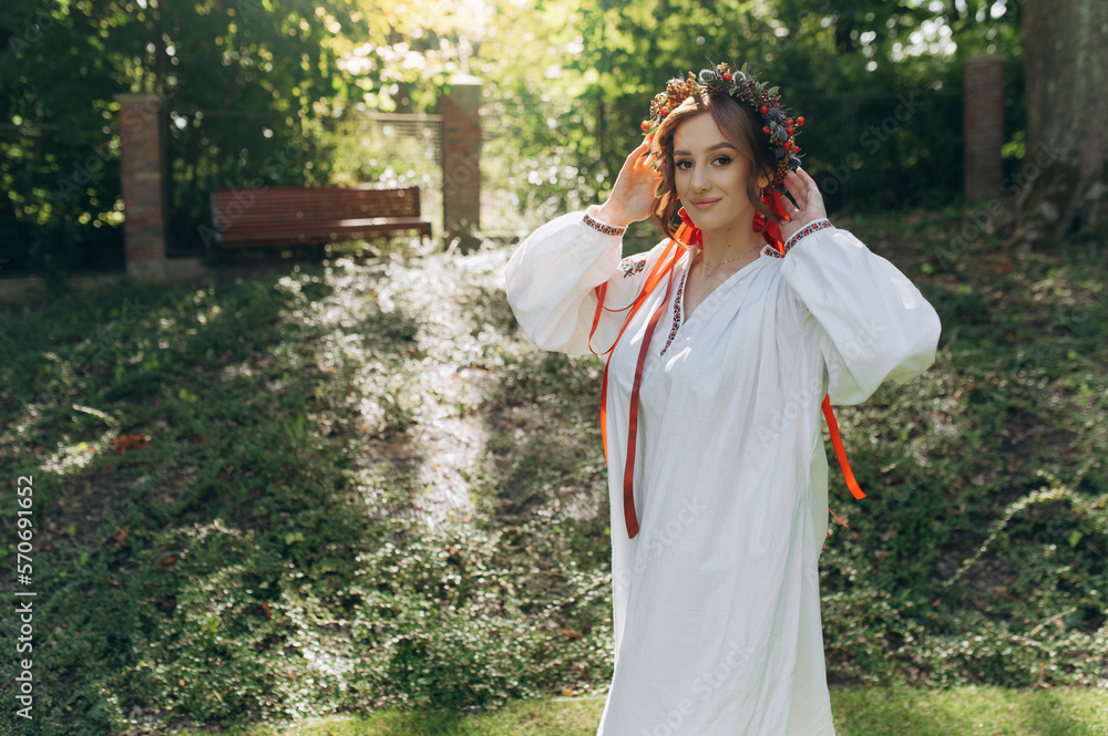 A girl in traditional Ukrainian clothes in nature. a girl in ethnic clothes with a wreath of flowers A girl in traditional Ukrainian clothes in nature. a girl in ethnic clothes with a wreath of flowers