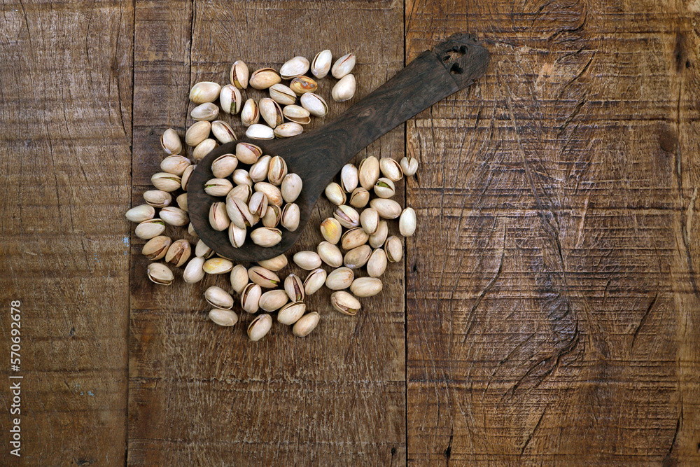 Portion of pistachio nuts in wooden table, Space for text Portion of pistachio nuts in wooden table, Space for text