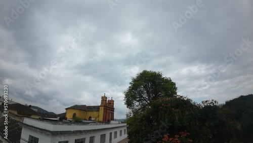 timelapse de nubes sobre iglesia católica amarilla en de un pueblo Chiapaneco. photo