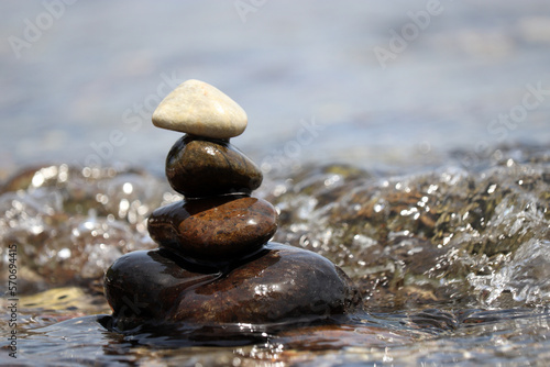 Tower of pebble stones on blurred background of sea waves. Beach vacation  balance and relax concept