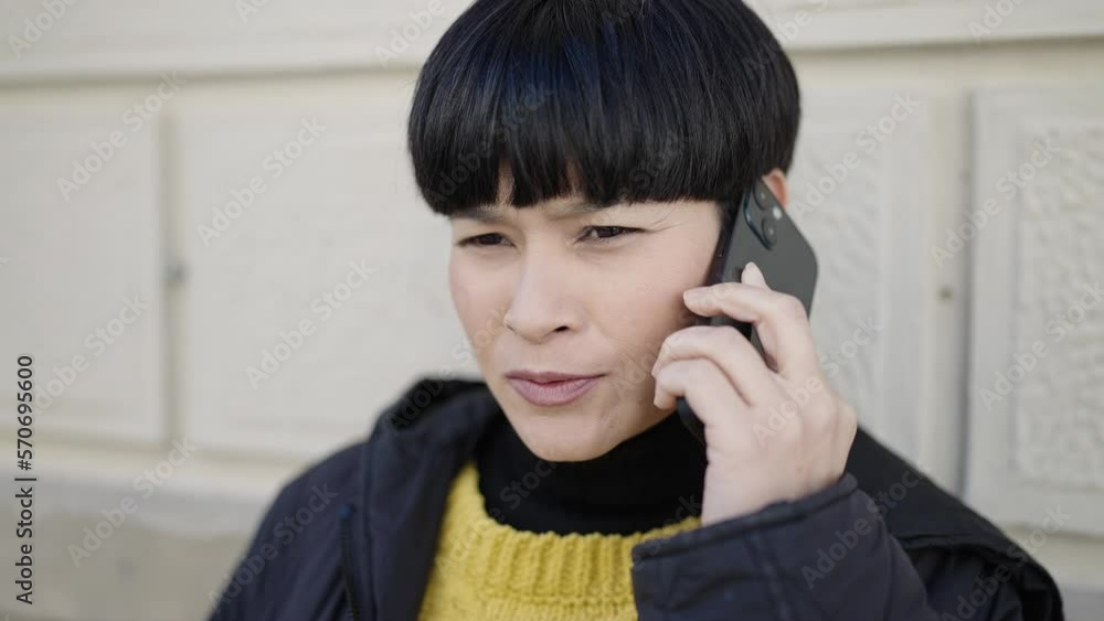 Young chinese woman talking on smartphone at street Young chinese woman talking on smartphone at street