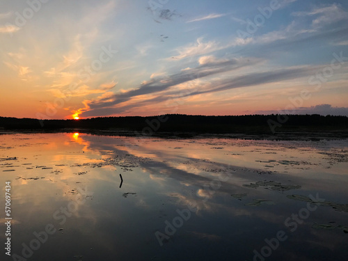 Sunset on a lake with blue skies and clouds reflecting in the water. Tourism and travel concept.