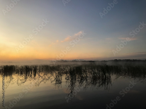 Fototapeta Naklejka Na Ścianę i Meble -  Summer, foggy landscape on the lake with blue sky with reflection of clouds in the lake. tourism and travel concept. high quality photo