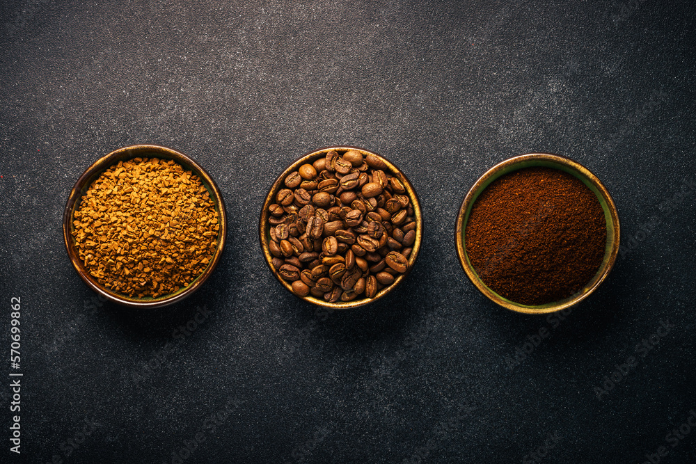 Roasted coffee beans, ground coffee and instant coffee in bowls at dark background. Top view image. Roasted coffee beans, ground coffee and instant coffee in bowls at dark background. Top view image.
