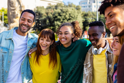 United multiracial young group of college student friends standing together outdoor. Diverse multi-ethnic happy people smiling while embracing each other in the city