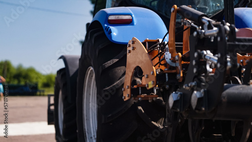 large blue tractor plowing field against the beautiful sky