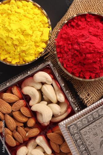 Holi festival of colors celebration with Colorful organic dry powder abeer gulal in traditional brass bowl with dry fruits a festival of India photo