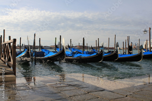 Venetian gondolas docked in the harbor on a windy day © Bjorn
