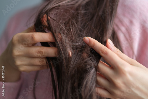 closeup female holding messy unbrushed dry hair in Hands. Hair damage concept.