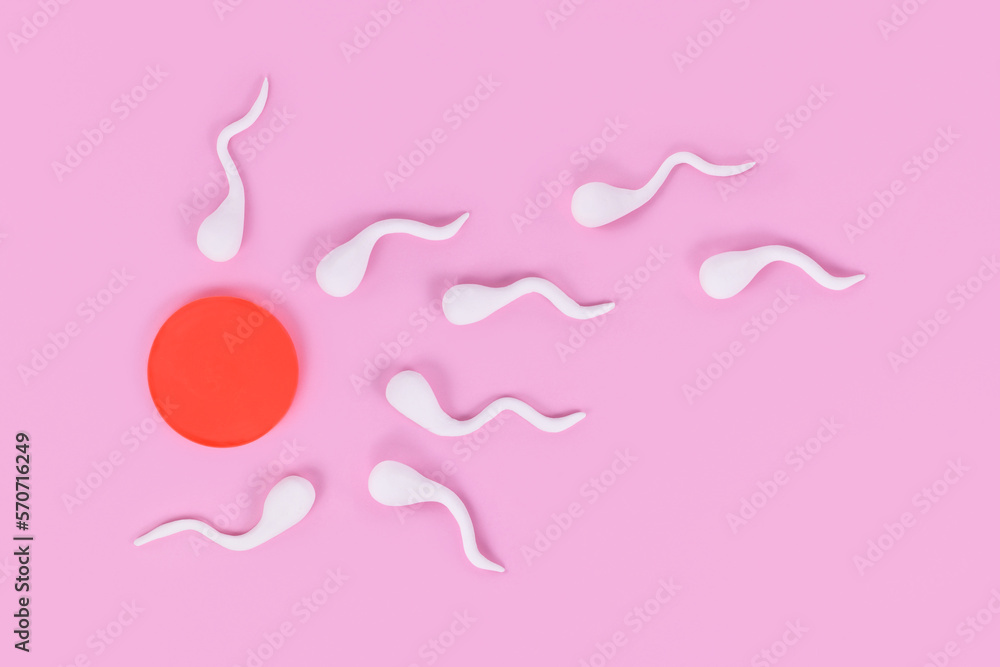 Abstract sperm cells swimming towards egg cell on pink background - obrazy, fototapety, plakaty 