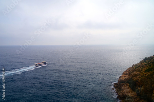 boat in the sea at the Costa Brava seen from the Cap de Tossa Lighthouse in Tossa de Mar, Catalonia, Spain, travel, tourism