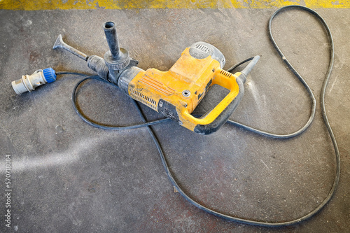 Professional demolition hammer on the floor in theindustrial shed. 