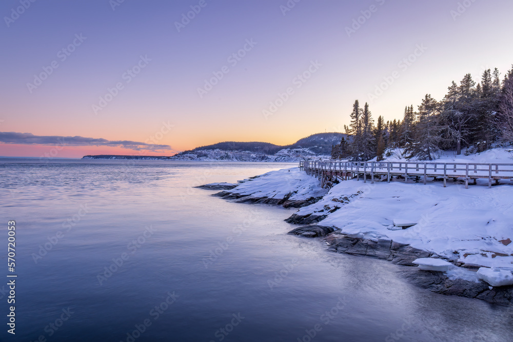 Fototapeta premium in Tadoussac the footbridge of the Pointe de l'Islet allows you to see whales. during a sunset in winter.