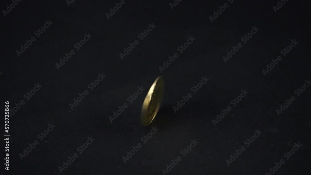 The bitcoin rotates on a black background sparkling in the sky and falls tails up. Rotation of a golden bitcoin coin in slow motion on a black background. Bitcoin spinning. The bitcoin rotates on a black background sparkling in the sky and falls tails up. Rotation of a golden bitcoin coin in slow motion on a black background. Bitcoin spinning.