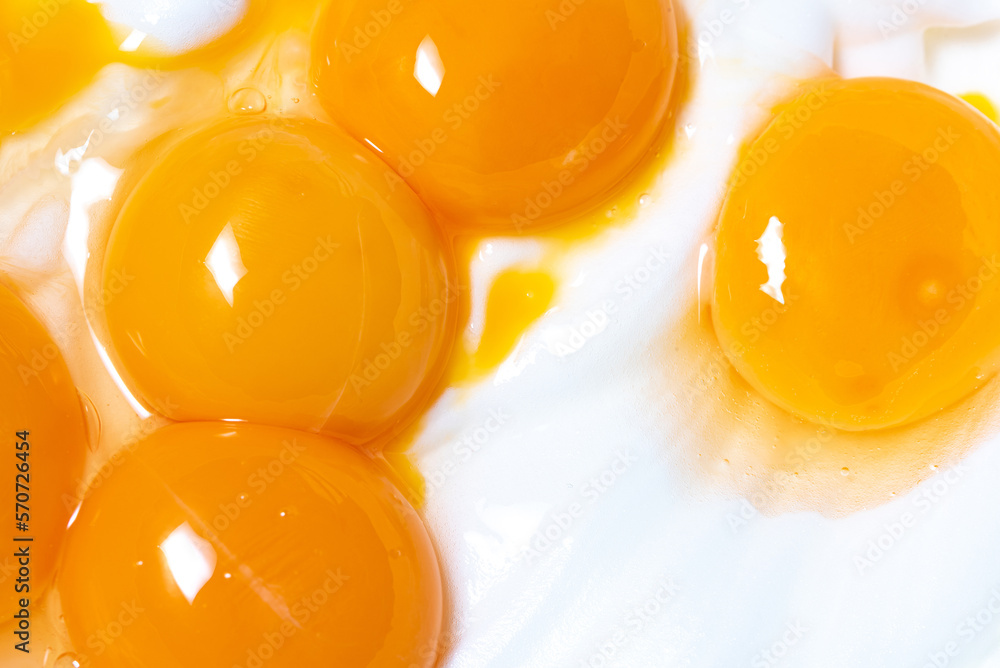 Egg yolks on whipped egg white foam. Close-up of broken eggs. - obrazy, fototapety, plakaty 