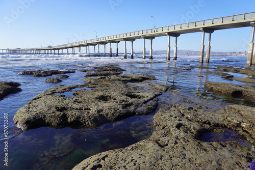 Tidepools at low tide with pier in the background. City in the far background. 