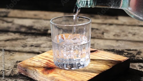 person pouring drink like mezcal, tequila or vodka in fancy glass