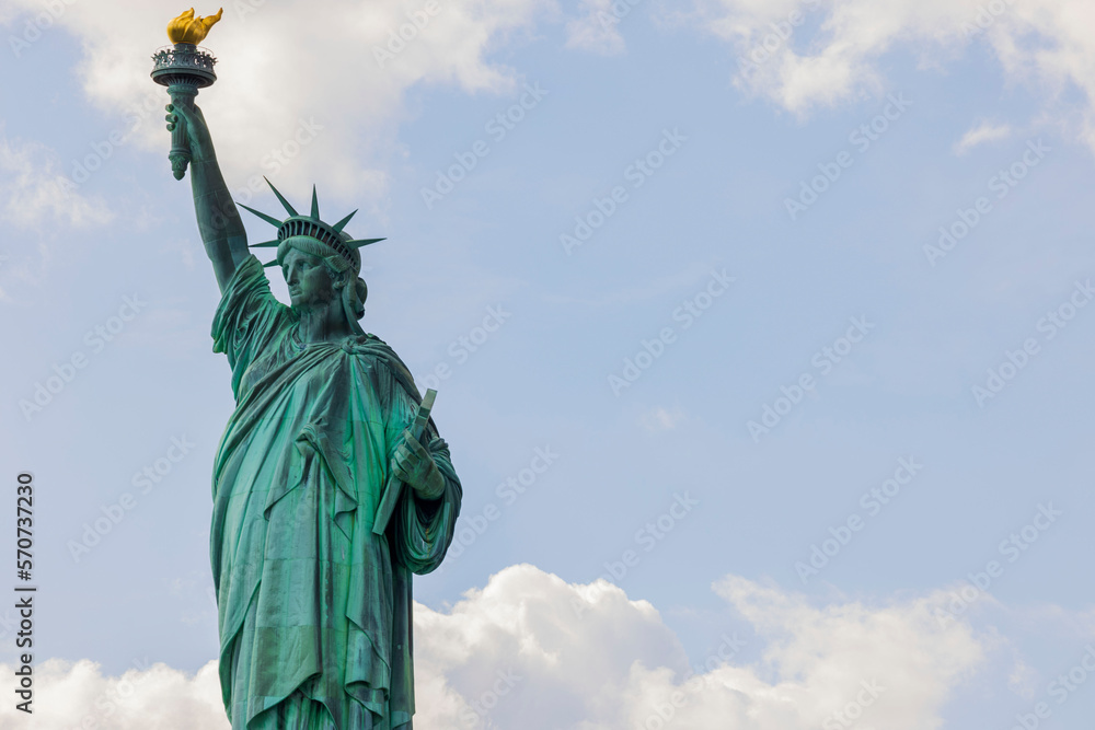 Fototapeta premium Close up view of Statue of Liberty against backdrop of white clouds. New York. USA.