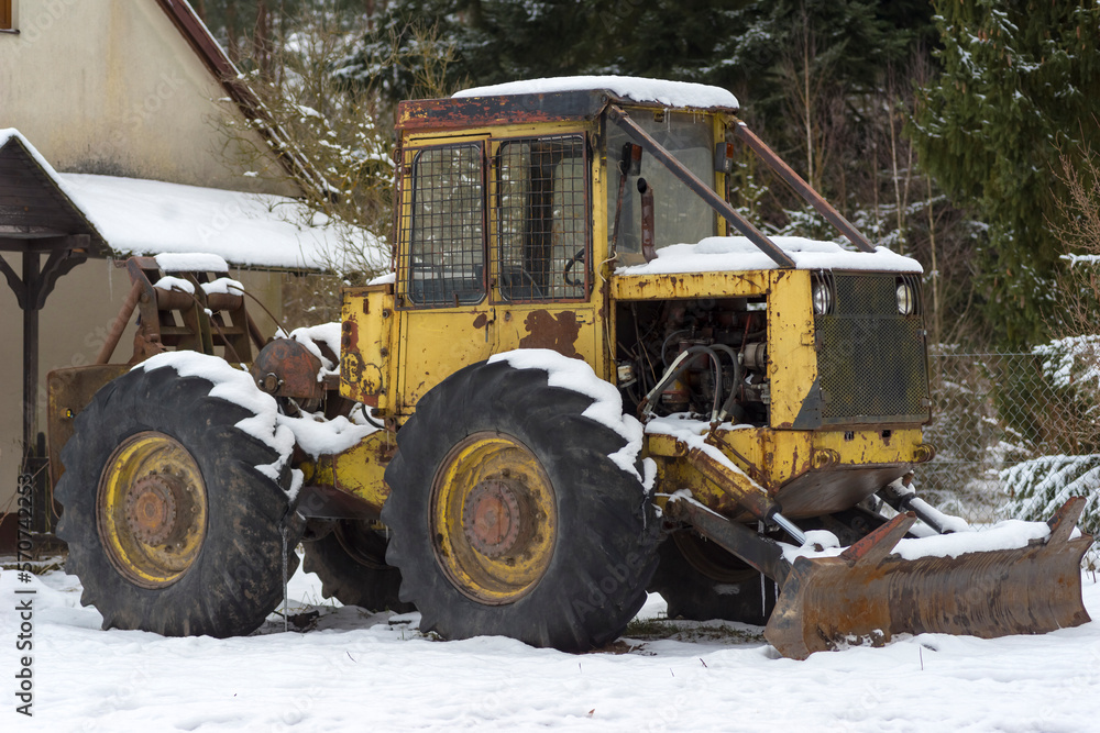Maszyna do leśnych prac , buldożer lub równiarka. Maszyna zaparkowana na zaśnieżonym terenie .