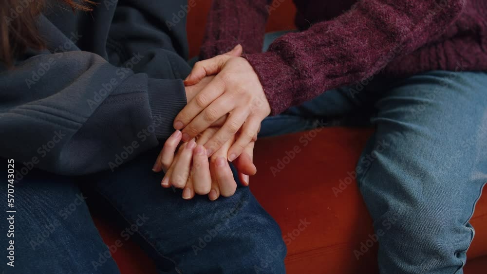 Close-up of two lesbian women family couple, girls friends holding caressing hands together, showing love to each other at home room sitting on couch. Woman relationship, LGBT same-sex people concept Close-up of two lesbian women family couple, girls friends holding caressing hands together, showing love to each other at home room sitting on couch. Woman relationship, LGBT same-sex people concept