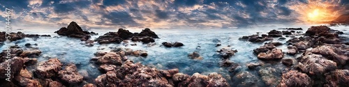 Rocky ocean shore featuring waves crashing against solid craggy stones breaching the ocean surface