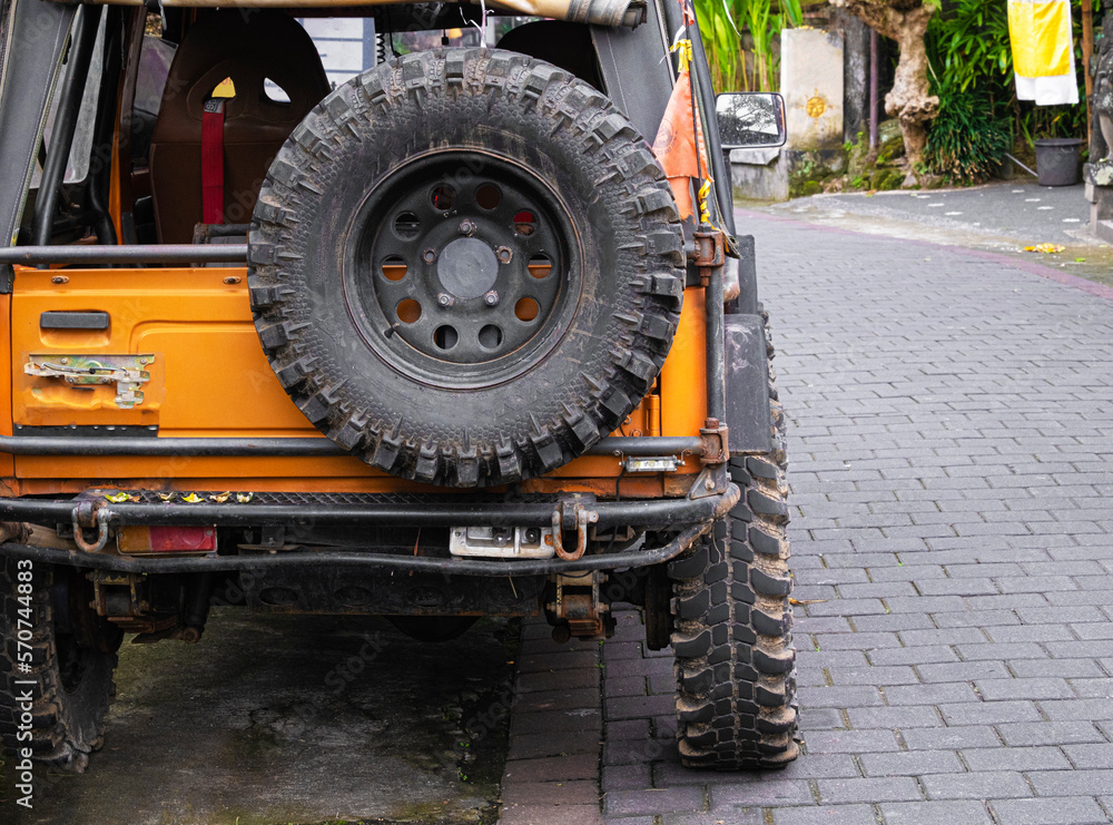 Rear view orange jeep parked on street in Bali Rear view orange jeep parked on street in Bali