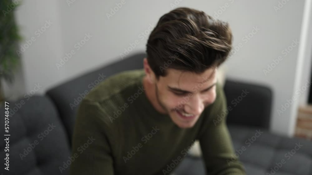 Young hispanic man using smartphone lying on sofa at home Young hispanic man using smartphone lying on sofa at home