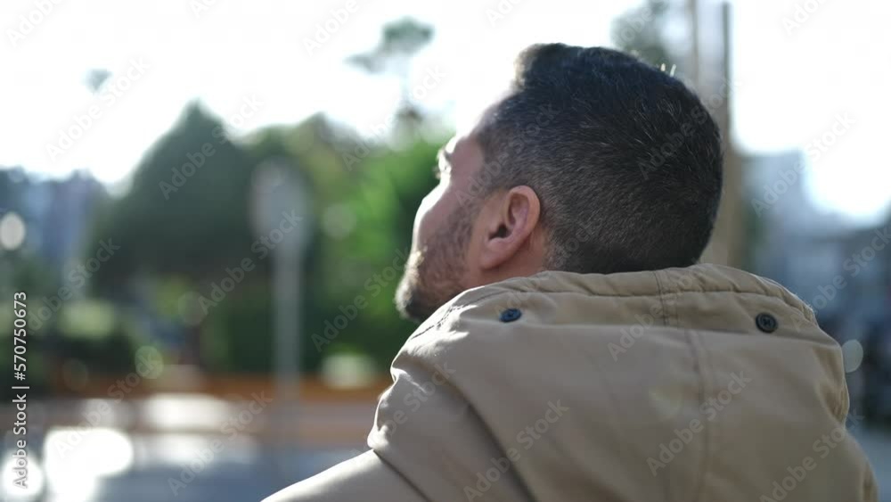 Young hispanic man standing on back view at park Young hispanic man standing on back view at park