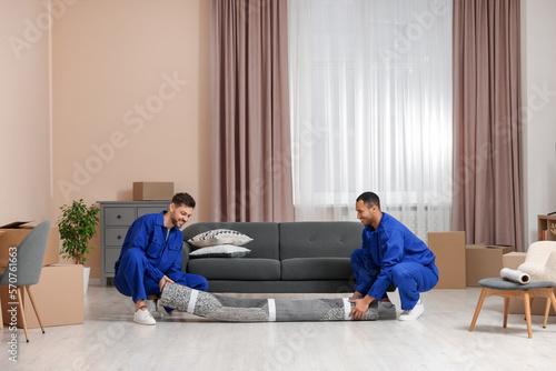 Male movers with carpet in new house © New Africa
