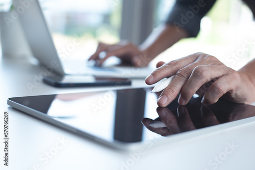 Business man using digital tablet and busy working on laptop computer with mobile phone on office table, business and technology, online working