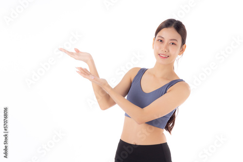 Portrait of beautiful young asian woman in sportwear smile and presenting isolated on white background, sport and exercise for health and weightloss, female and slimming showing something. © N_studio
