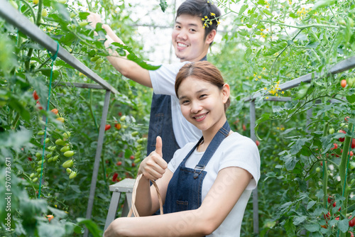 Young couple thumbs up enjoy gardening on farm