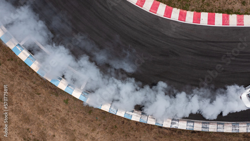 Aerial top view white car drifting with lots of smoke from burning tires on speed track, Car drifting on speed track, Sport car wheel drifting and smoking.