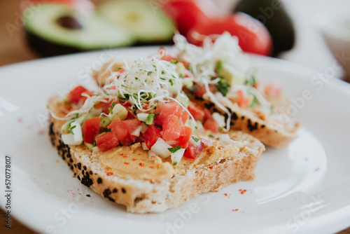 tostada toasted bread with tomato on wooden table, closeup