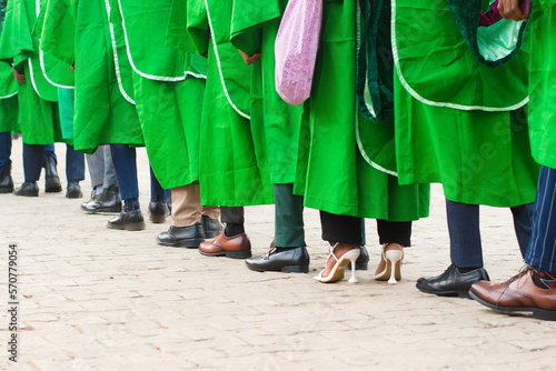 Line up of university graduating students wearing their green graduation outfit and marching towards the school reception hall for their pass out ceremony in Nigeria