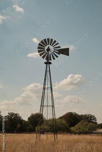 typical American water pumping windmill in a field of dried grass photo