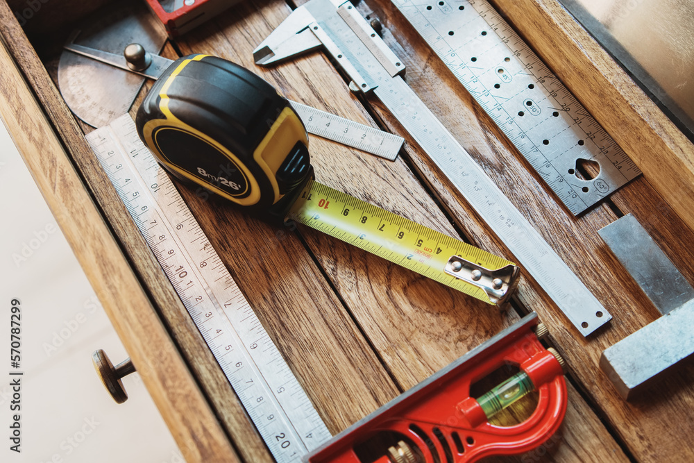 Tape measure with linear-measured markings on wooden background, DIY maker and woodworking concept. selective focus