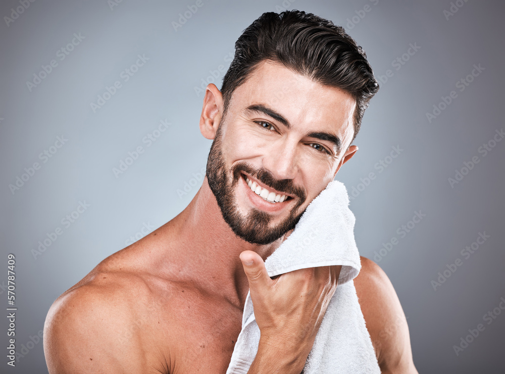 Fototapeta premium Skincare, wellness and portrait of a happy man in a studio with a self care, natural and face routine. Health, dermatology and male model with a facial towel for treatment isolated by gray background