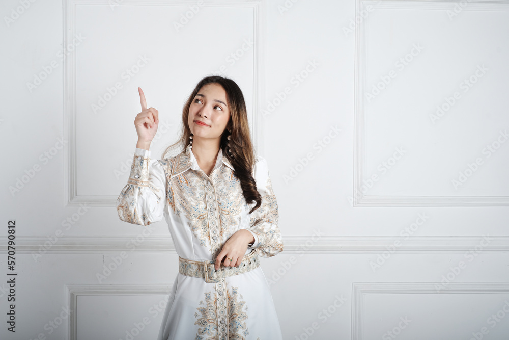 Asian girl pointing to empty space with the hand and fingers. 