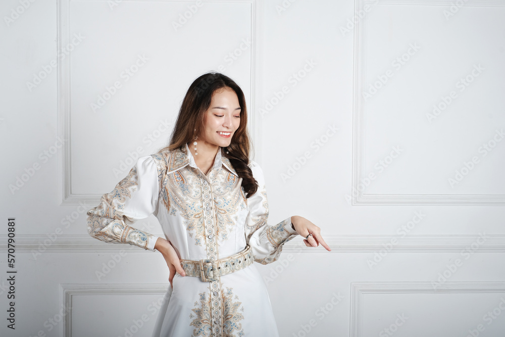 Asian girl pointing to empty space with the hand and fingers. Asian girl pointing to empty space with the hand and fingers.