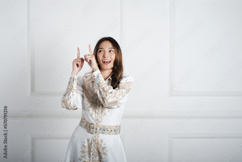 Asian girl pointing to empty space with the hand and fingers. Asian girl pointing to empty space with the hand and fingers.