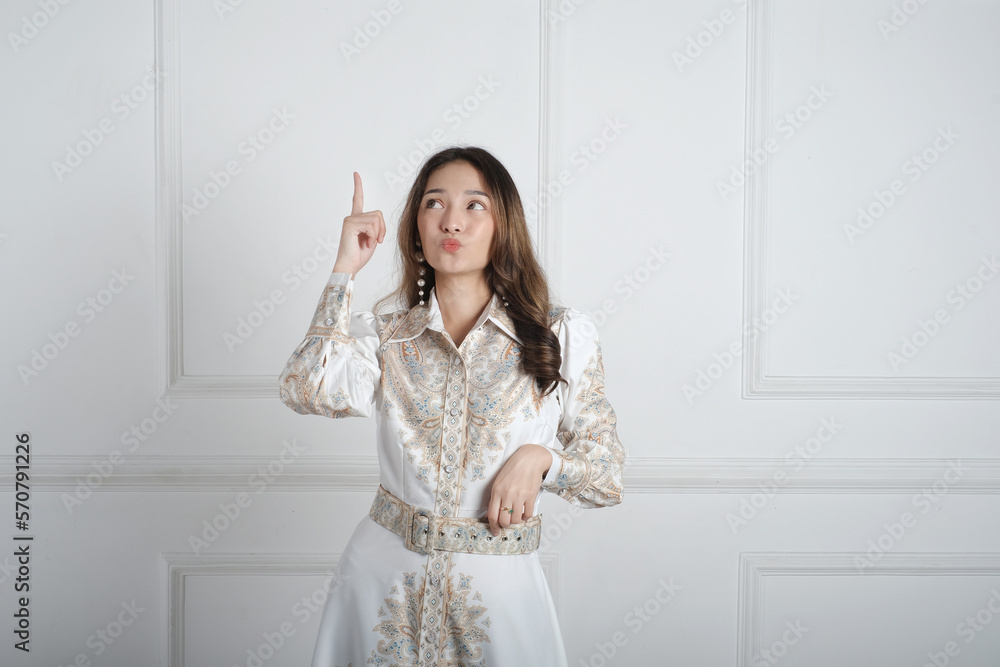 Asian girl pointing to empty space with the hand and fingers. Asian girl pointing to empty space with the hand and fingers.