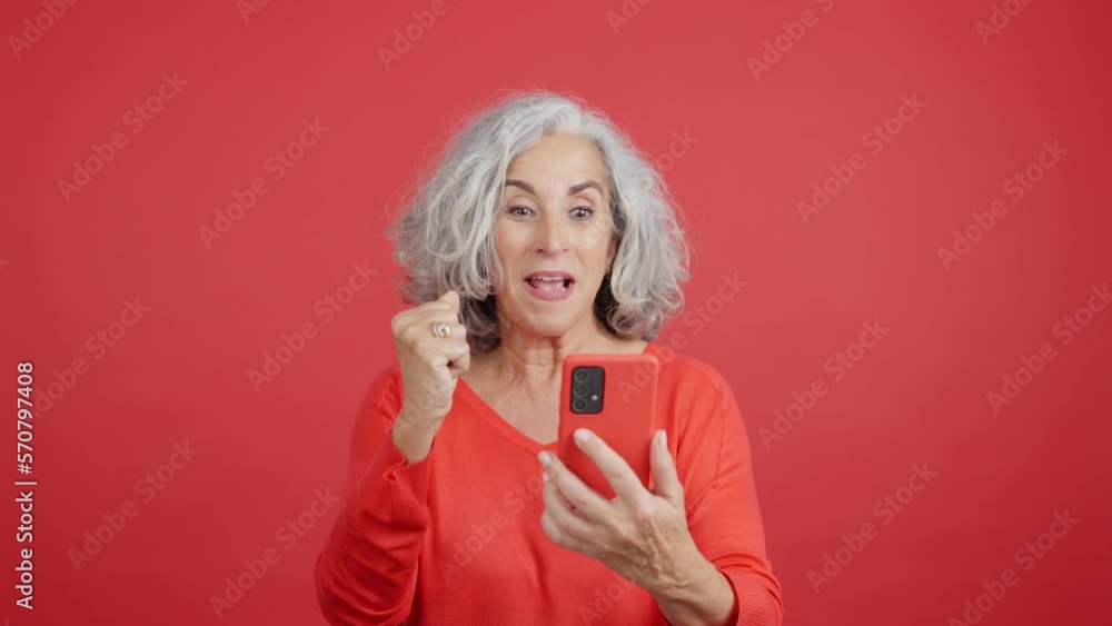 Mature woman celebrating while using the mobile phone Mature woman celebrating while using the mobile phone