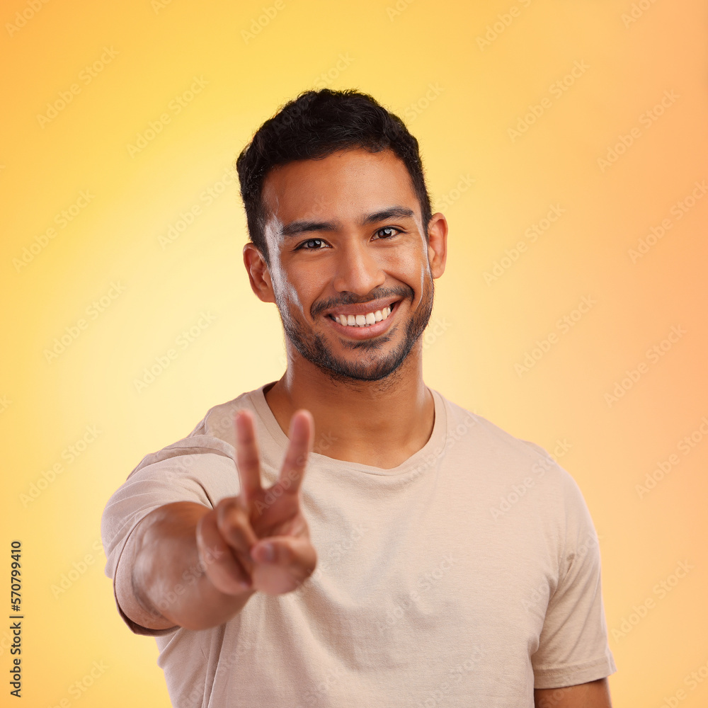 Portrait, hands and man with peace sign in studio isolated on a yellow background. Face, fashion and hand gesture, v symbol or emoji of happy young male model in stylish, designer and cool clothing. Portrait, hands and man with peace sign in studio isolated on a yellow background. Face, fashion and hand gesture, v symbol or emoji of happy young male model in stylish, designer and cool clothing.