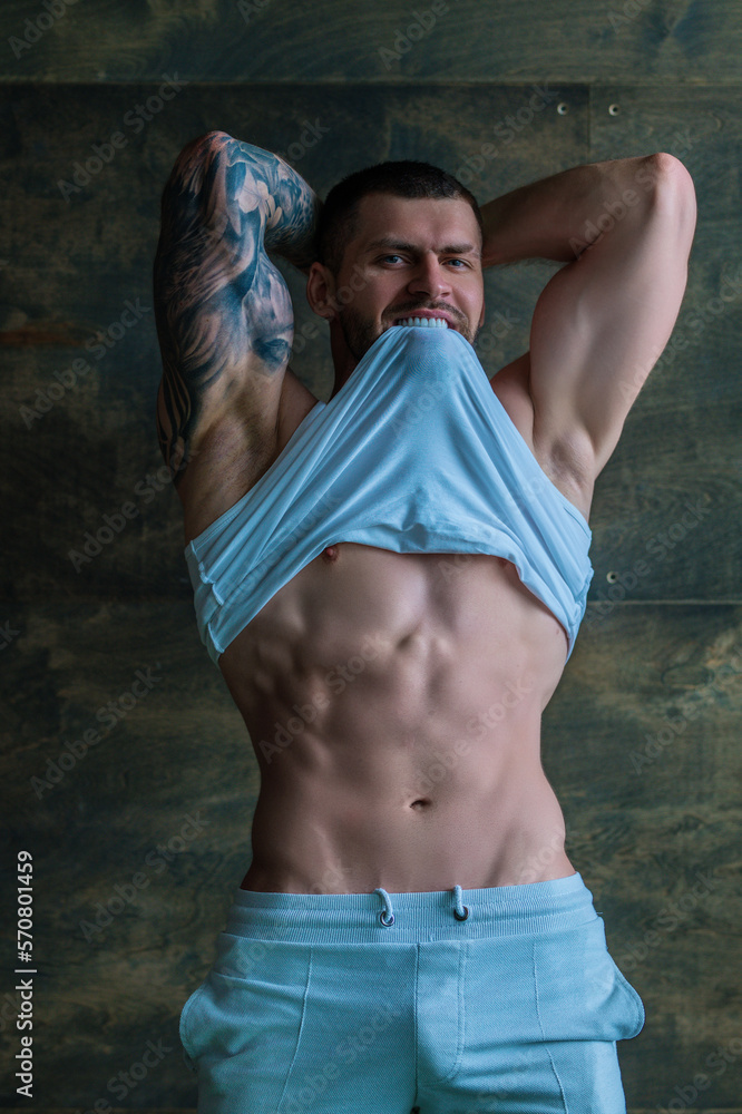 Sexy and naked muscular young man posing indoors. Sexy shirtless male