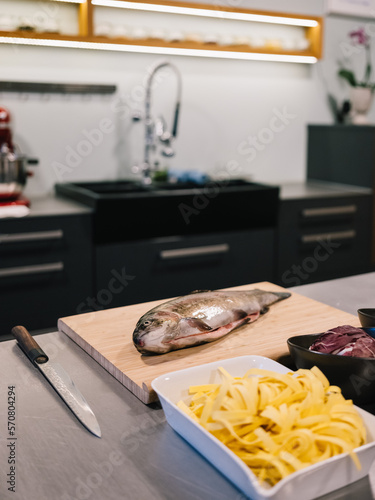 Frischer Fisch an der Unterseite aufgeschnitten liegt auf der Küchenarbeitsplatte (ID: 570804294)