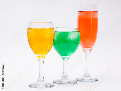 Three glasses with different liquors on white background.