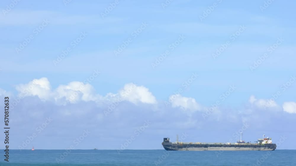 this is a coal carrier parked at sea with beautiful clouds and unique