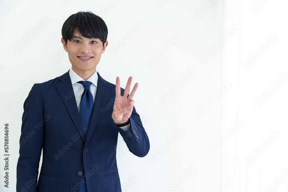 3本指を立てる男性ビジネスパーソン 3本指を立てる男性ビジネスパーソン