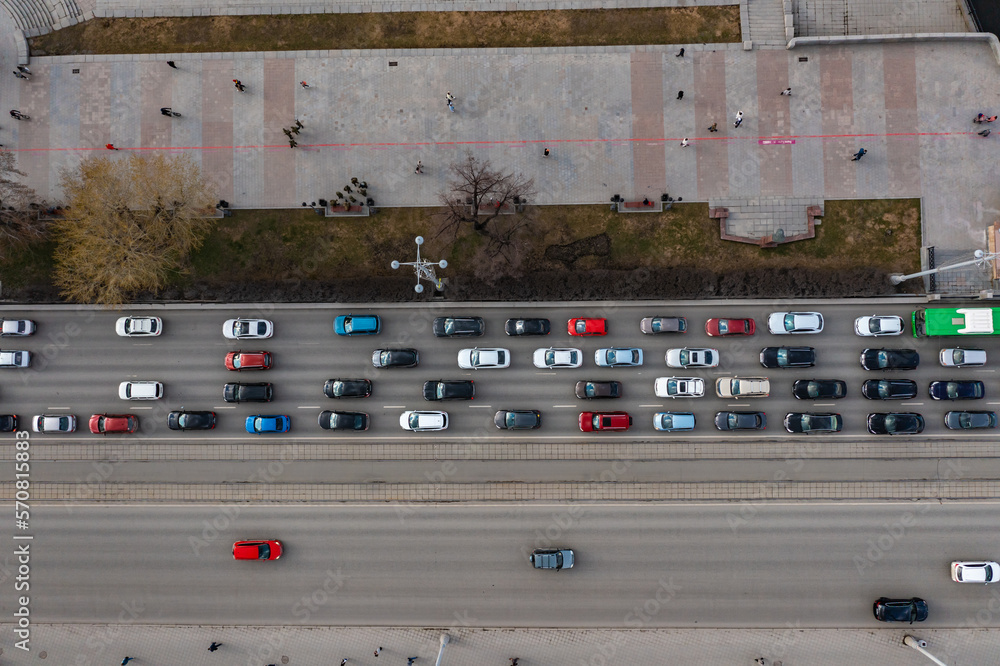Top-down aerial drone flight View of a highway in a busy city during rush hour. Aerial view of intersection for vehicles, showing heavy traffic and numerous vehicles on the road,